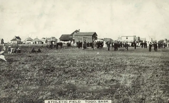 Athletic field with crowd and town buildings
